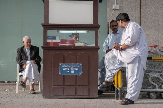 Una conversazione nel negozio di un orologiaio davanti a un supermercato nel quartiere di Al-Sadd