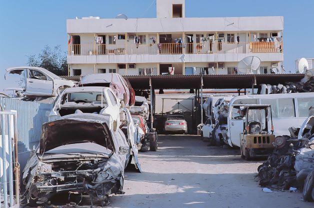 Autodemolitore e piccoli alloggi collettivi nella zona industriale di Doha (Al-Sanaiyah) dove vive la maggior parte dei lavoratori stranieri, nella parte ovest della città, non lontano dalla base militare americana di Al-Udeid 