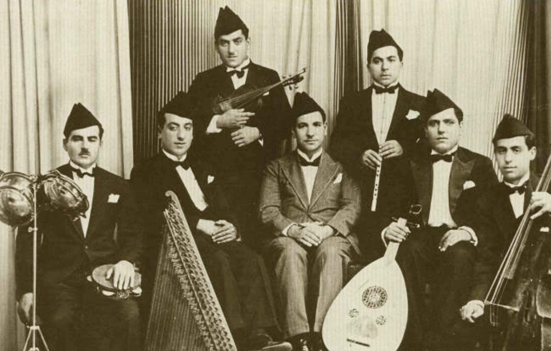 مجموعة من الموسيقيين يرتدون بدلات رسمية ويعزفون آلات موسيقية متنوعة.