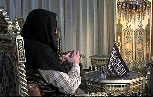 الصورة تظهر مشهداً بين شخصين يجلسان على كراسي مزخرفة. الشخص في الجهة اليسرى يرتدي ملابس تقليدية ويحمل بيديه بعض الأشياء. بينما الشخص في الجهة اليمنى يبدو أنه يقرا من كتاب أو ملاحظات. الخلفية تحتوي على زينة تقليدية، مع إضاءة ناعمة تعكس أجواء الحوار.