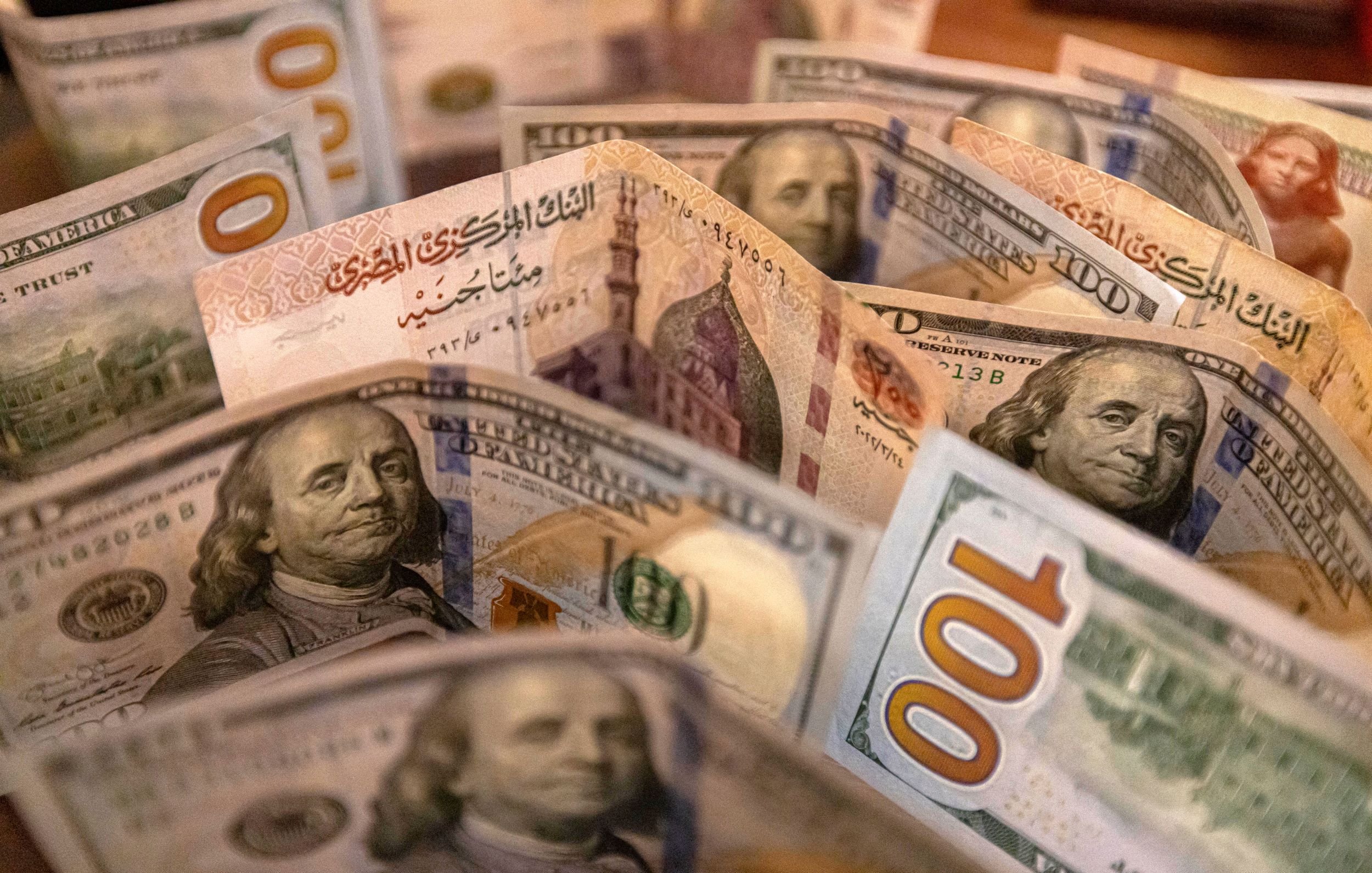 تظهر الصورة مجموعة من الأوراق النقدية الأمريكية من فئة المئة دولار. تتوزع الأوراق بشكل متقارب، مع ظهور وجه بنيامين فرانكلين على الأوراق. الخلفية تشير إلى تفاصيل أخرى، مما يضفي عمقًا للصورة. الألوان بارزة وواضحة، مما يجعل الأوراق النقدية تبدو جديدة وجذابة.