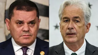 الصورة تُظهر شخصين مختلفين، حيث يظهر كل منهما على جانب. الشخص على اليسار يرتدي بدلة داكنة مع ربطة عنق، ويظهر عليه تعبير جاد. الشخص على اليمين يرتدي بدلة رمادية ولديه لحية خفيفة، ويبدو أنه يتحدث أو يعبر برأيه. الخلفية تتضمن تفاصيل بسيطة وغير واضحة.