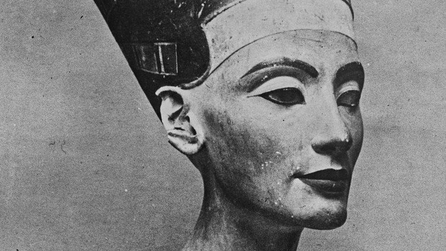 The image depicts a famous ancient Egyptian sculpture known as the bust of Nefertiti. It features a detailed representation of a woman's head, elegantly adorned with a tall, flat headdress. The sculpture showcases Nefertiti's graceful facial features, including high cheekbones and a delicate neck. The colors are predominantly shades of beige and cream, with remnants of painted details on the headdress and necklace. This artwork is renowned for its beauty and serves as a significant artifact from ancient Egypt, reflecting the artistry of the time.