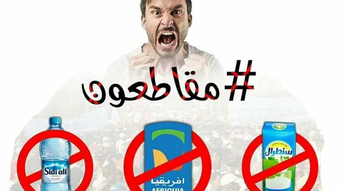 The image features a man expressing anger or frustration, likely as part of a protest or social movement. The text includes the word "مقاطعون" (meaning "we boycott" in Arabic) and suggests a call for a boycott against certain products, as represented by crossed-out symbols of specific beverages: Sidi Ali (a water brand), Afriquia (a drink brand), and another beverage. The background shows a crowd, indicating that this is related to a larger movement or demonstration. Overall, it conveys a strong message of dissent against these brands.