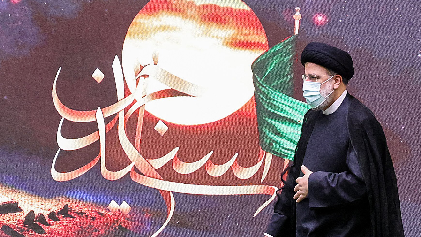 در این تصویر، یک مرد در لباس رسمی و با عمامه مشکی در حال راه رفتن است. او ماسک به صورت دارد و پشت او تصاویری از یک پسزمینه هنری با رنگهای گرم و نمادهایی مربوط به تاریخ یا فرهنگ دیده میشود، از جمله پرچم سبز. متن خوشنویسی شدهای در تصویر وجود دارد که به زبان فارسی نوشته شده است. این تصویر ممکن است به یک مراسم مذهبی یا ملی مرتبط باشد.