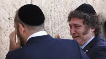 در این تصویر، دو مرد یهودی را مشاهده میکنیم که در کنار دیواری ایستادهاند. یکی از آنها در حال گریه کردن است و احساسات عمیقی را نشان میدهد. هر دو مرد کلاه یهودی (کیپا) بر سر دارند و در حال ادای احترام یا دعا به دیوار هستند. دیوار ممکن است دیوار گریه باشد که برای یهودیان مقدس است. پسزمینه تصویر با سنگهای بی شکل و طبیعی پر شده است.