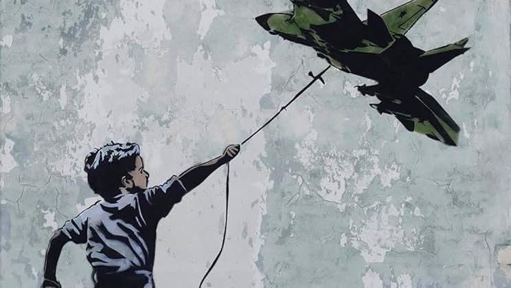 L'image représente un garçon courant joyeusement, tenant une ficelle à laquelle est suspendu un avion de chasse. Le mur en arrière-plan est rugueux et décoloré, ce qui met en valeur le contraste entre la figure du garçon et l'avion. Cette œuvre pourrait symboliser des thèmes comme l'innocence de l'enfance face à la guerre ou la rêverie de l'évasion.