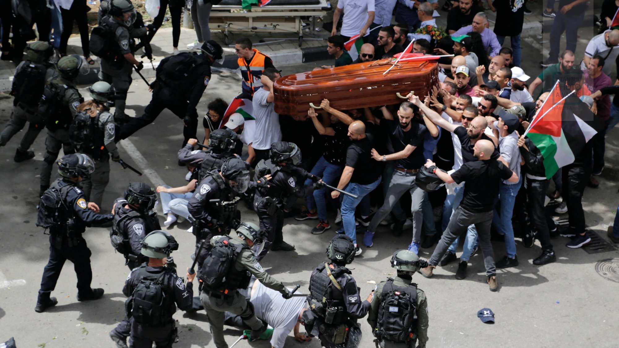 Des manifestations violentes avec des policiers en tenue anti-émeute et un cercueil.