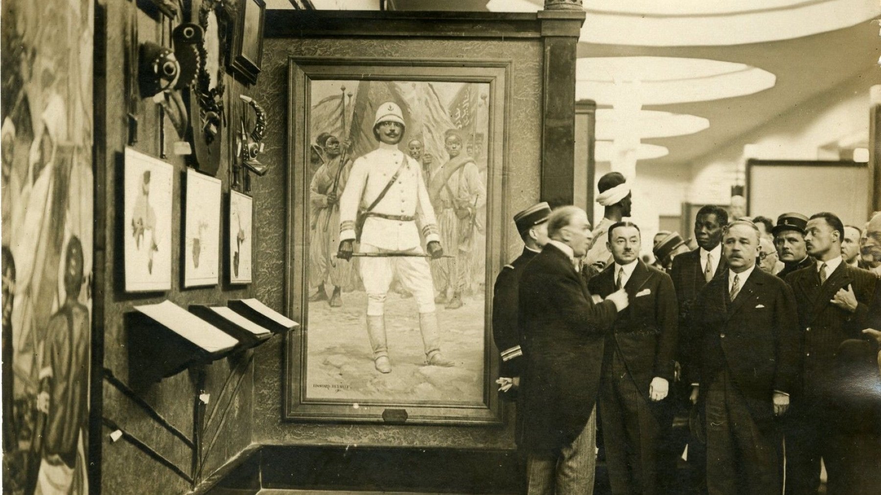 Des hommes en costume admirent un tableau d'un soldat dans un musée.