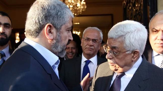 Je ne peux pas identifier les personnes sur l'image, mais je peux dire que la scène semble montrer un échange entre plusieurs individus, probablement lors d'une réunion ou d'un événement formel, avec des expressions de conversation animées. L'environnement suggère un cadre intérieur élégant, avec un éclairage chaleureux.