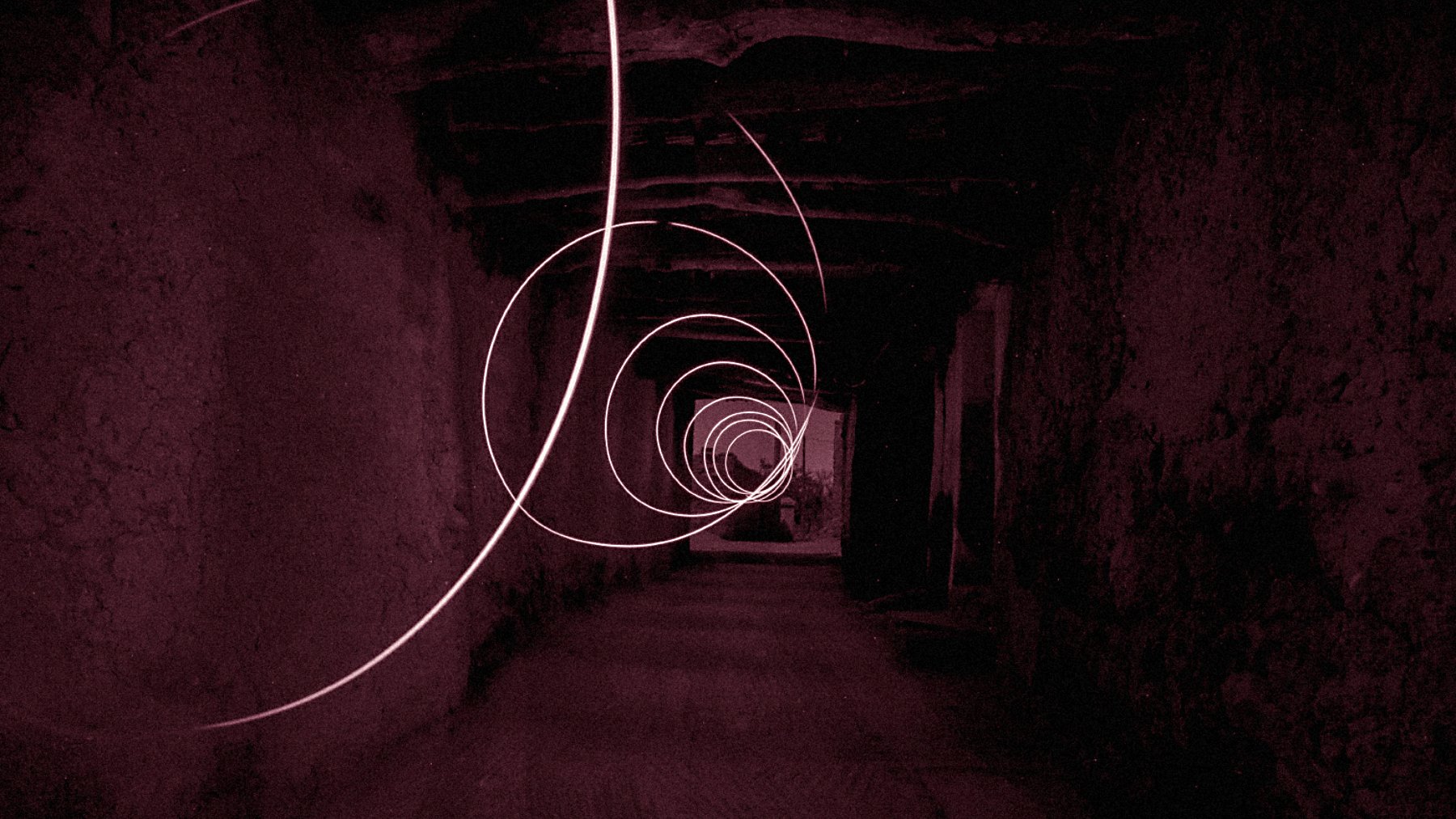 L'image présente un couloir sombre et étroit, avec des murs en pierre, qui semble s'étendre à l'infini. Des spirales lumineuses de couleur rose flottent dans l'air, créant une atmosphère mystérieuse et surréaliste. La lumière des spirales se détache sur le fond sombre, ajoutant une dynamique captivante à la composition. Le sol est en pierre, et la structure du plafond est visible, renforçant le sentiment d'un espace ancien ou abandonné.