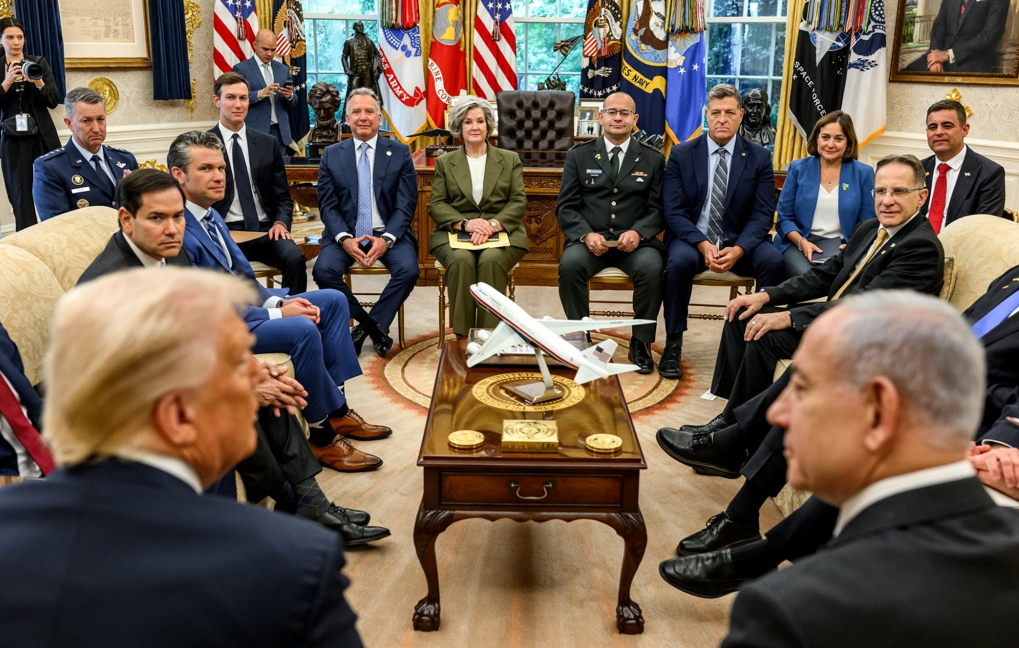 Des responsables politiques discutent autour d'une table dans un bureau officiel.