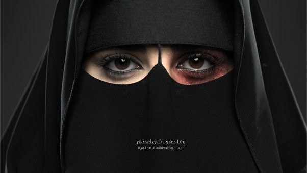 L'image montre une femme portant un niqab, couvrant la majeure partie de son visage. Ses yeux sont mis en valeur, l'un d'eux ayant un maquillage sombre, tandis que l'autre semble plus clair. Cette composition crée un contraste saisissant. En bas de l'image, il y a un texte en arabe et le logo de la Fondation King Khalid. L'image semble porter un message puissant et engageant.