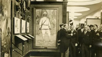 Des hommes en costume admirent un tableau d'un soldat dans un musée.