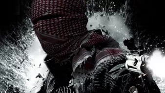 L'image montre une silhouette masquée, vêtue d'un keffieh, tenant des armes. En arrière-plan, des éclats suggèrent une scène d'action intense. Le design est sombre et évoque une ambiance militarisée, avec des éléments graphiques qui renforcent le sentiment de tension. Un symbole ou un logo est également présent au bas de l'image.