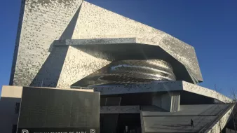 Bâtiment moderne aux formes ondulées, façade métallique, situé à Paris.