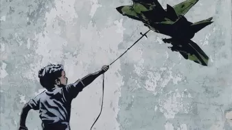 L'image représente un garçon courant joyeusement, tenant une ficelle à laquelle est suspendu un avion de chasse. Le mur en arrière-plan est rugueux et décoloré, ce qui met en valeur le contraste entre la figure du garçon et l'avion. Cette œuvre pourrait symboliser des thèmes comme l'innocence de l'enfance face à la guerre ou la rêverie de l'évasion.