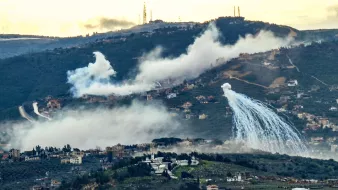 Nuages de brume et jets d'eau sur une colline, paysage montagneux.