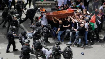 Des manifestations violentes avec des policiers en tenue anti-émeute et un cercueil.