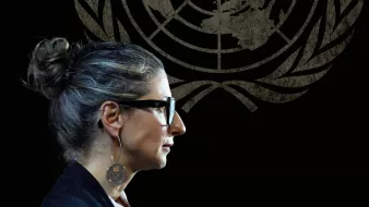 Femme avec des lunettes, coiffure en chignon, silhouette sur fond du logo de l'ONU.