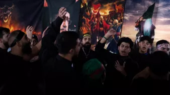 Des hommes en vêtements noirs chantent et montrent des signes de dévotion.