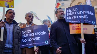L'image montre un groupe de personnes participant à une manifestation. Elles tiennent des pancartes avec des messages clairs, notamment "No to Islamophobia. No to war." et "Stop the War Coalition". Les manifestants expriment leur opposition à l'islamophobie et à la guerre. On peut voir des personnes de divers âges et origines, toutes unies par leur cause. L'ambiance semble engagée et déterminée.