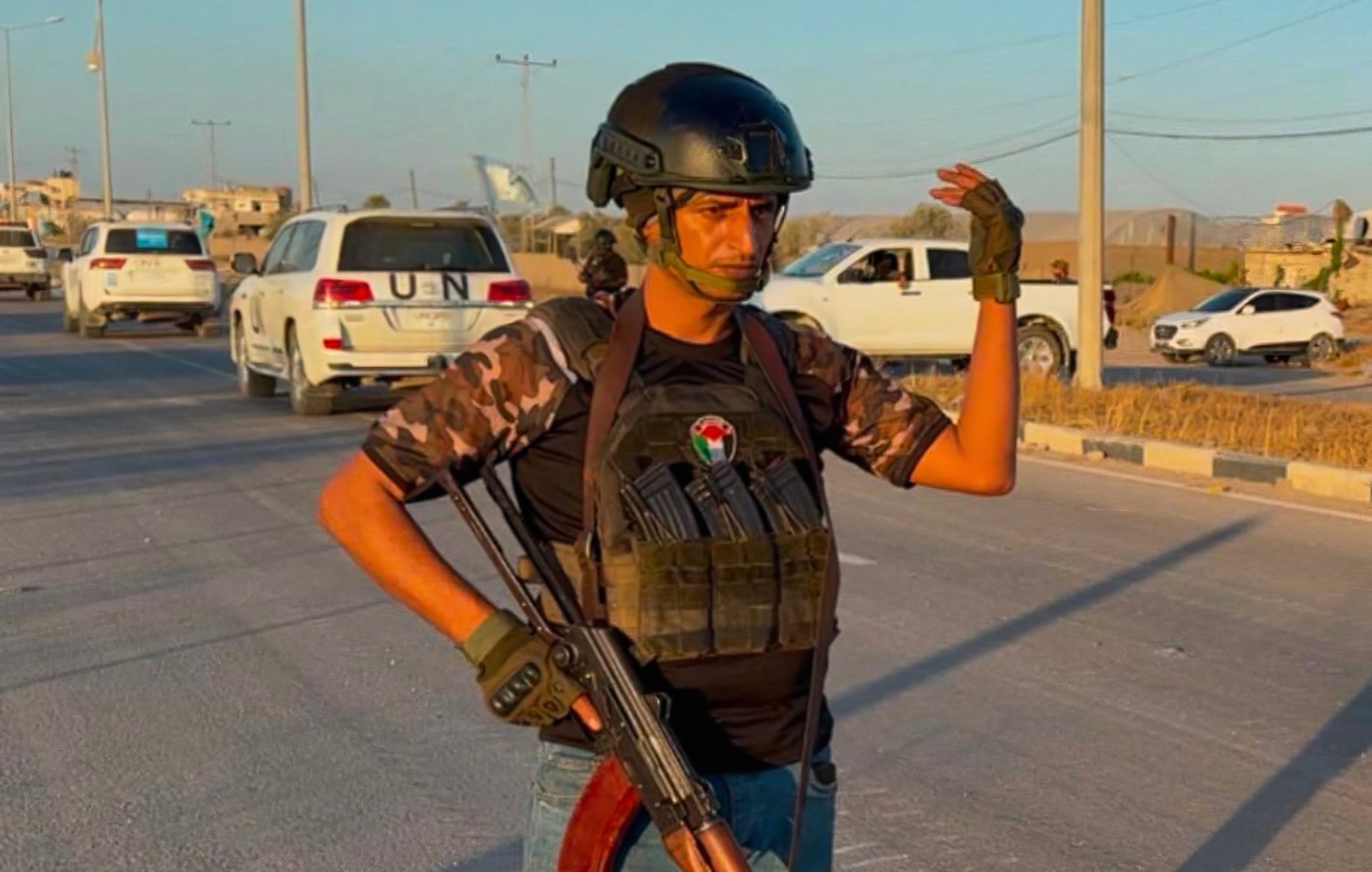 Un uomo in uniforme militare, con un fucile e un elmetto, si erge su una strada.