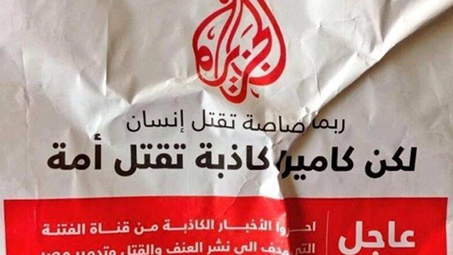 L'image montre une affiche avec du texte en arabe et en français. Elle semble émettre un message urgent, probablement en rapport avec des événements violents ou des conflits. Le design est simple, avec un fond clair et un accent sur le texte, ce qui suggère qu'il s'agit d'une communication importante. Le logo d'Al Jazeera est également visible, ce qui indique que l'affiche pourrait être liée à un rapport ou à des nouvelles diffusées par ce média.