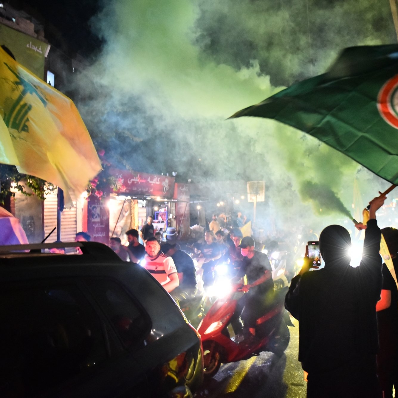 مظاهرة حيوية مليئة بالأعلام والدخان الملون، مع أجواء من الحماس والضجيج.