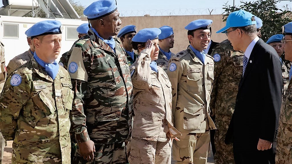 تظهر الصورة مجموعة من الأفراد العسكريين يرتدون بزات الأمم المتحدة الزرقاء، ويبدو أنهم في موقع رسمي. يوجد شخص يحاول التحية، في حين يبدو أن هناك اجتماعًا أو زيارة يقوم بها أحد الشخصيات المهمة. المجموعة تشمل أفرادًا من خلفيات عسكرية متنوعة، ويبدو أن هناك تواصلًا ونقاشًا بينهم. الجو العام يبدو جادًا ومهنيًا، وربما يشير إلى مهمة سلمية.