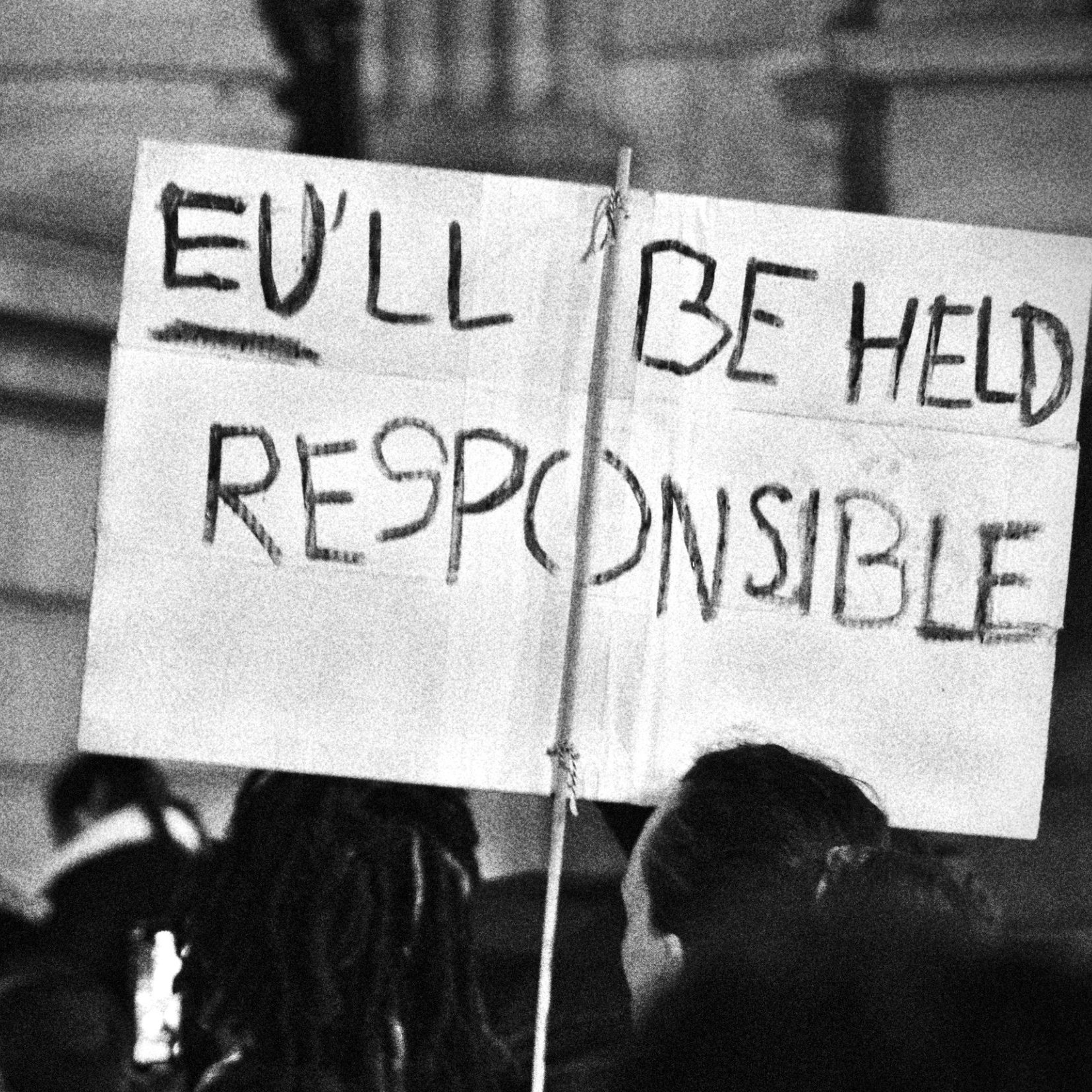 Un cartello con la scritta "You'll be held responsible" in un contesto di protesta.