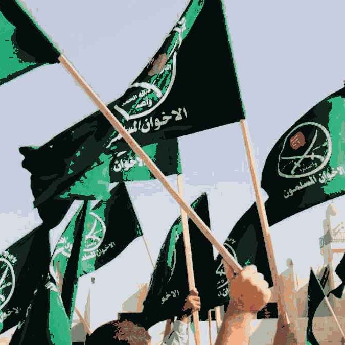The image features a multitude of green flags being waved, likely during a rally or demonstration. The flags bear inscriptions and symbols, which may represent a specific political or ideological group. The overall atmosphere suggests a sense of unity and enthusiasm among the participants. The background may include people and structures, emphasizing the communal aspect of the event.