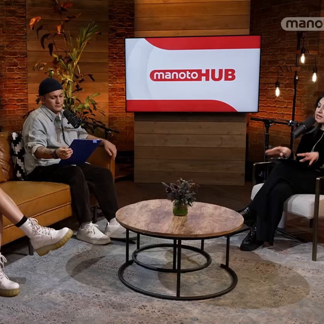 سه فرد نشسته‌اند در یک استودیو با دکور چوبی. یک تلویزیون بزرگ با لوگوی "manotoHUB" در پس‌زمینه است.