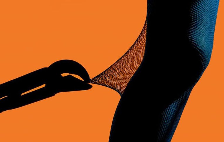 L'image montre une silhouette humaine, probablement une jambe, portant des collants en filet. Un outil (possiblement une pince) semble tirer sur le collant, créant une tension visuelle intéressante. En arrière-plan, une couleur orange vive attire l'œil et crée un contraste frappant avec la silhouette sombre. L'ensemble évoque une sensation de dynamisme et d'innovation.