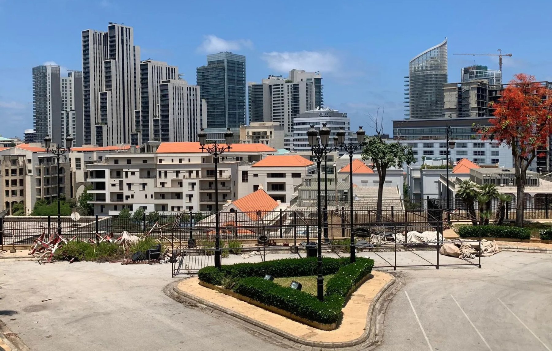 A cityscape featuring modern skyscrapers, residential buildings, and landscaped areas.