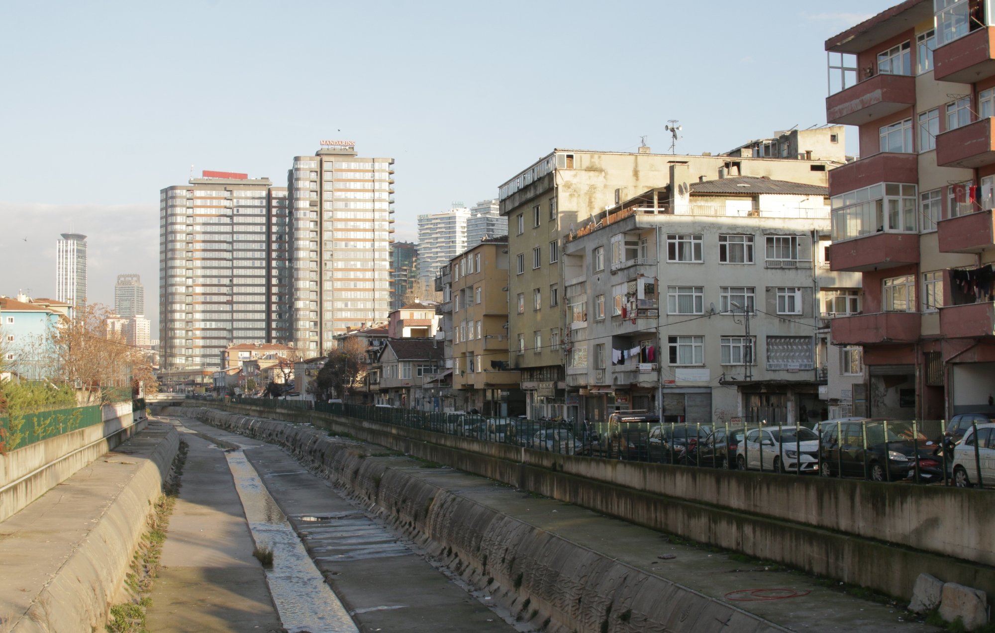 Vue d'une rue avec des immeubles modernes et des bâtiments anciens, le tout au bord d'un canal.