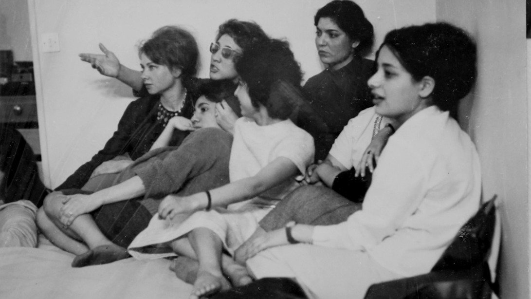 Un groupe de femmes assises, discutant et écoutant attentivement, visages concentrés.