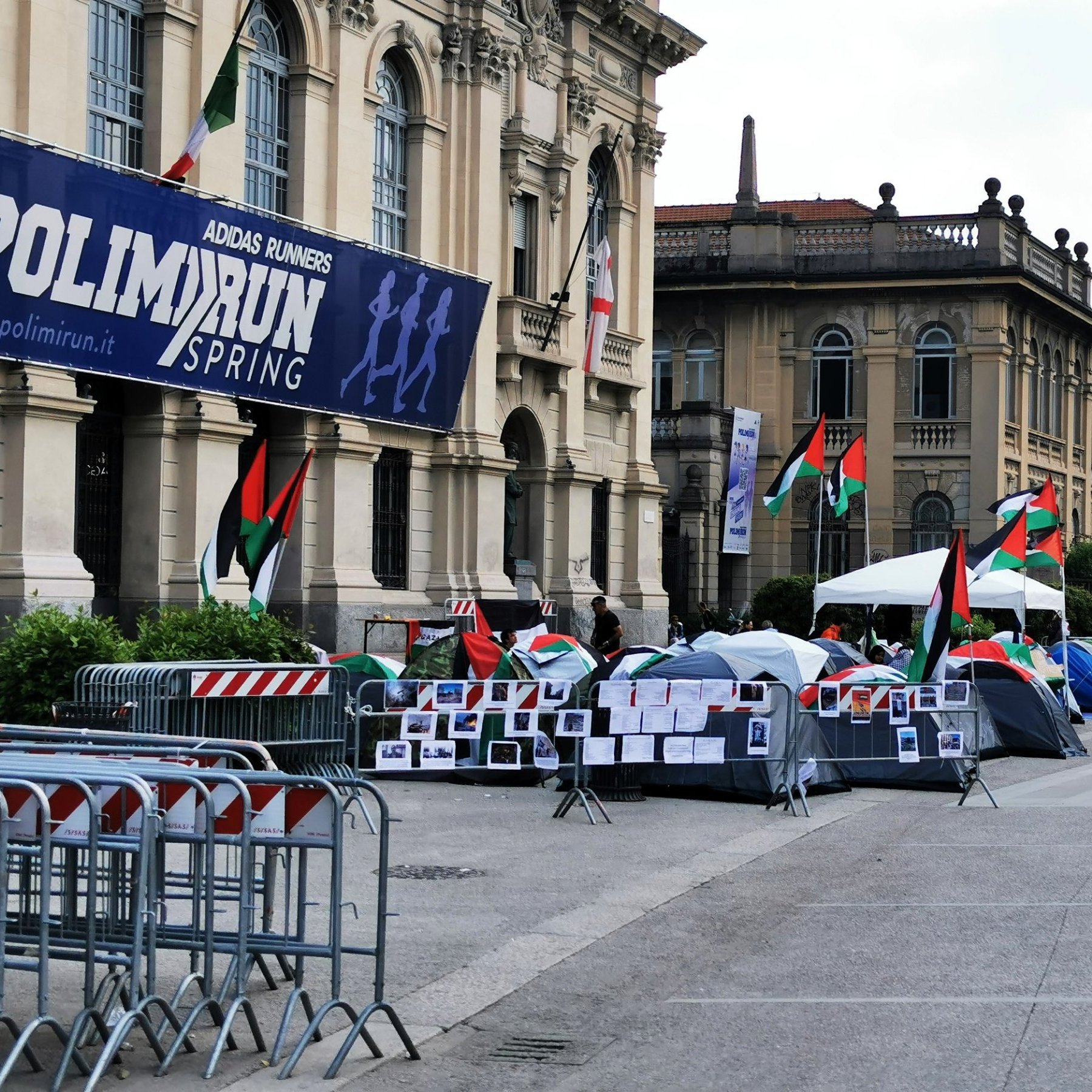 Un campo con tende, bandiere palestinesi e cartelli di protesta.