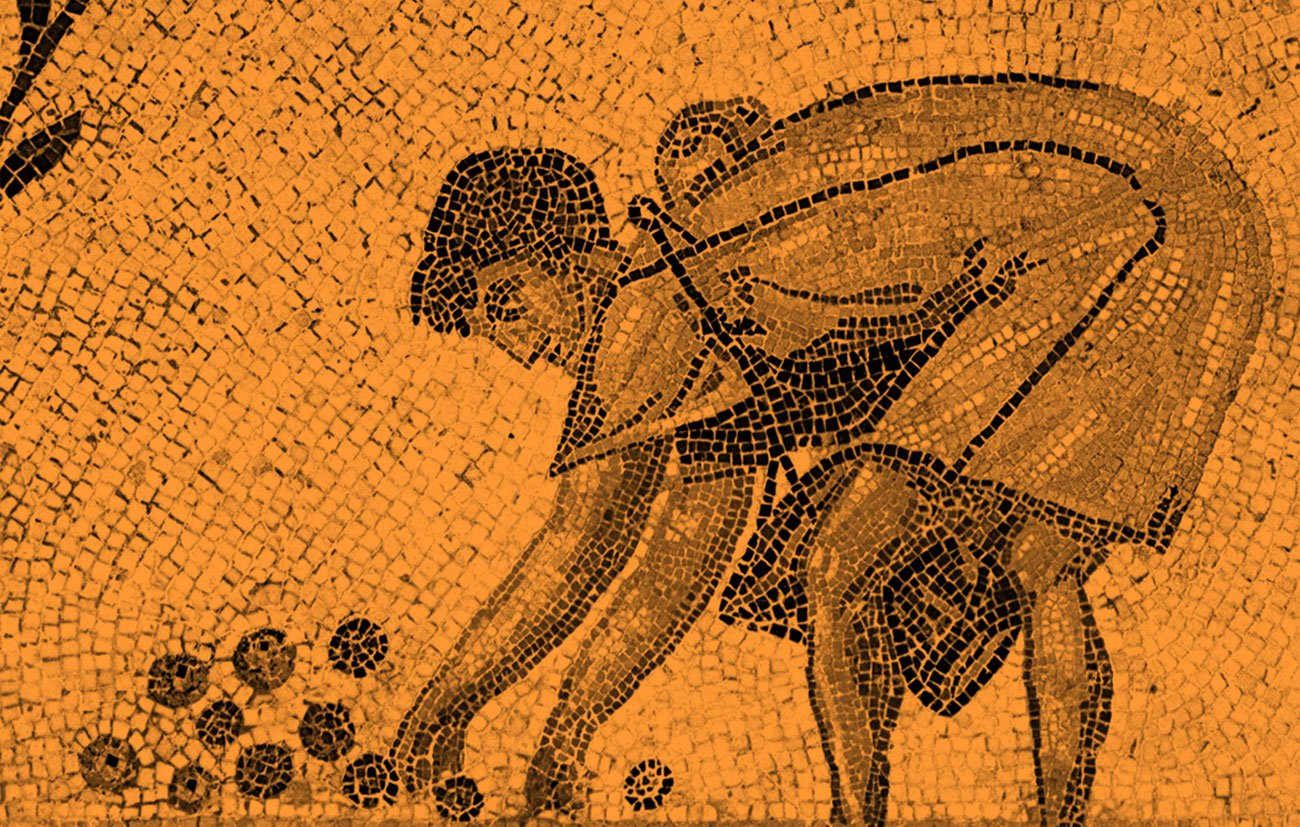 L'image montre une mosaïque représentant une scène de récolte. On y voit une figure humaine, probablement un jeune homme, accroupie en train de ramasser des fruits, probablement des oranges ou des pommes. Le personnage est dessiné avec des tesselles de couleur claire et foncée, créant un contraste intéressant avec le fond. L'ensemble de la composition semble évoquer le travail des champs et la connexion à la nature.