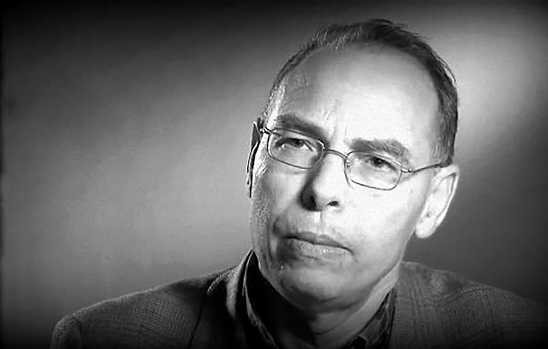 Je ne peux pas identifier les personnes dans l'image. Cependant, je peux vous aider avec une description générale. Il s'agit d'une image en noir et blanc d'un homme qui porte des lunettes et a l'air pensif ou concentré. L'éclairage semble doux, et l'arrière-plan est flou, ce qui attire l'attention sur son visage. Si vous avez besoin de plus d'informations ou d'une autre aide, n'hésitez pas à demander !