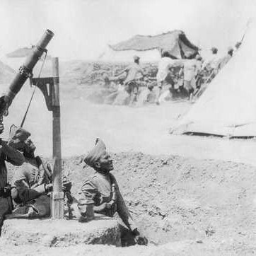 در این تصویر، تعدادی سرباز در حال کار با یک خمپاره‌انداز دیده می‌شوند. آن‌ها در یک سنگر قرار داشته و یکی از آن‌ها در حال هدف‌گیری خمپاره است. در پس‌زمینه، گروهی از سربازان دیگر مشغول فعالیت هستند و چندین چادر نظامی در دوردست مشاهده می‌شود. فضای تصویر نشان‌دهنده یک صحنه نظامی و فعالیت‌های جنگی است.