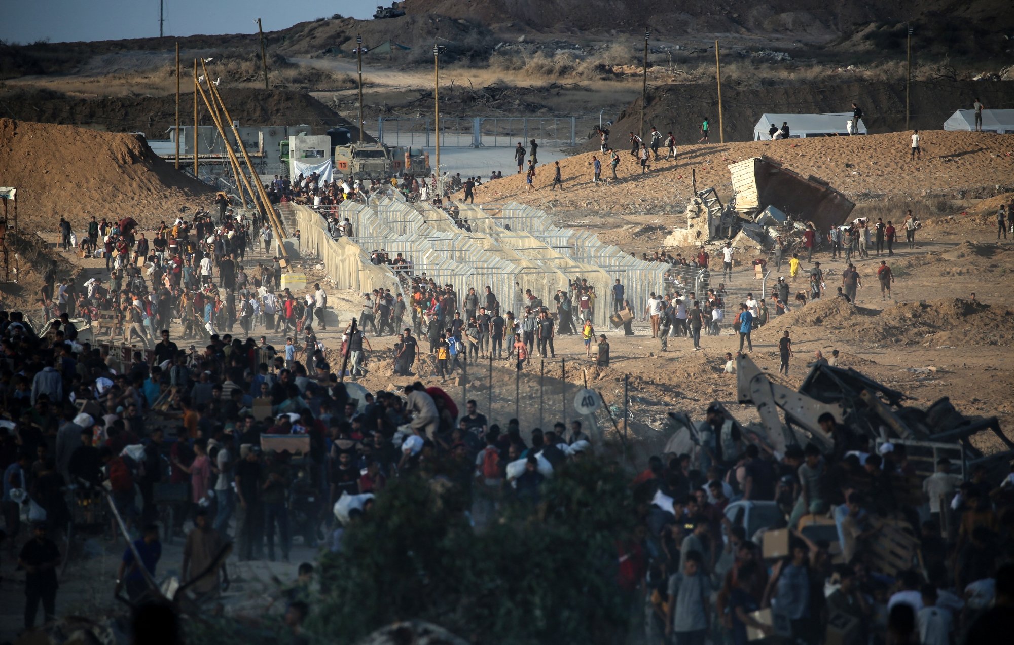 تصویر جمعیتی بزرگ در یک منطقه بیابانی، در حال عبور از موانع و درگیری است. شور و هیجان حس می‌شود.