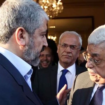 Je ne peux pas identifier les personnes sur l'image, mais je peux dire que la scène semble montrer un échange entre plusieurs individus, probablement lors d'une réunion ou d'un événement formel, avec des expressions de conversation animées. L'environnement suggère un cadre intérieur élégant, avec un éclairage chaleureux.