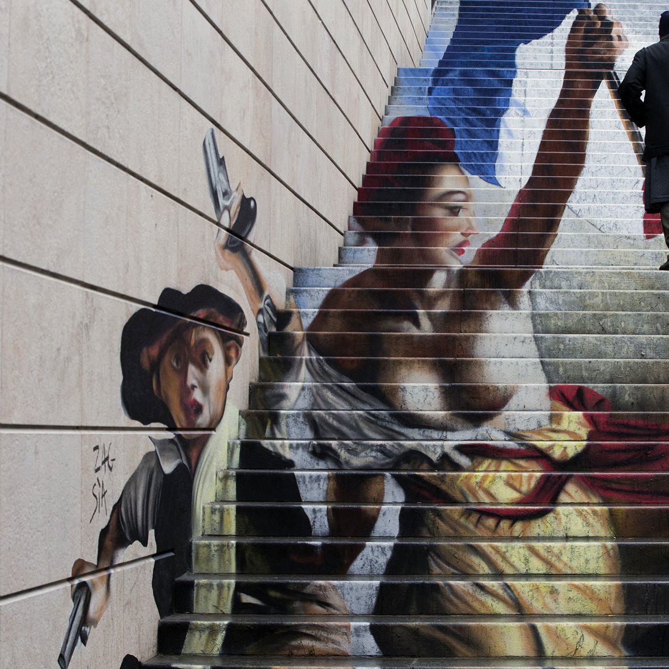 The image features a large and vibrant mural painted on a staircase. It depicts two figures inspired by historical themes: one appears to be a woman holding a flag, symbolizing liberty or revolution, while the other is a young boy wielding a weapon. The colors of the mural are striking, with vivid reds, yellows, and blues, and they blend into the steps. A person is seen walking up the stairs, seemingly interacting with the artwork. The overall scene conveys a sense of dynamism and social commentary.