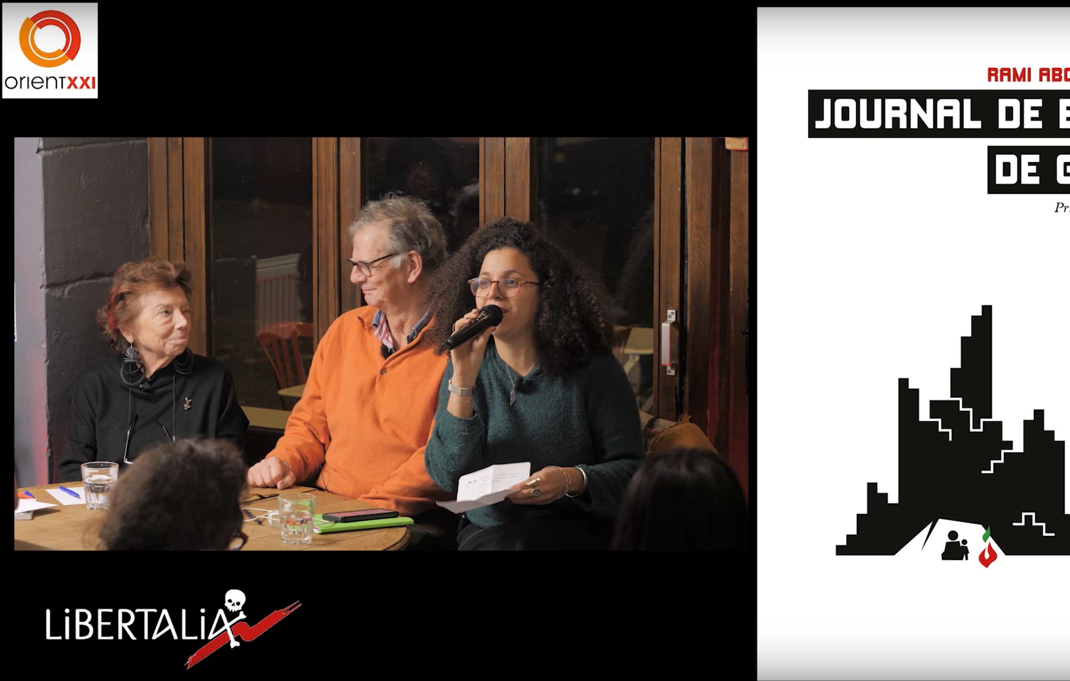 L'image montre un événement en cours avec des participants assis autour d'une table. À gauche, un homme et une femme discutent, la femme tenant un micro et s'adressant à l'audience. L'homme à ses côtés sourit et semble attentif. À droite, il y a une couverture d'un livre intitulé "Journal de bord de Gaza", avec des éléments graphiques stylisés. Le tout évoque une ambiance conviviale et engagée, orientée vers la discussion d'une œuvre littéraire ou d'une thématique importante.