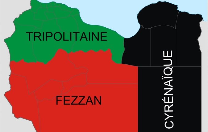 L'image montre une carte de la Libye, divisée en trois régions principales. La partie supérieure est la Cyrénaïque, représentée en noir. La région au centre est le Fezzan, en rouge, tandis que la partie supérieure gauche est la Tripolitaine, indiquée en vert. Chaque couleur représente une région distincte du pays.
