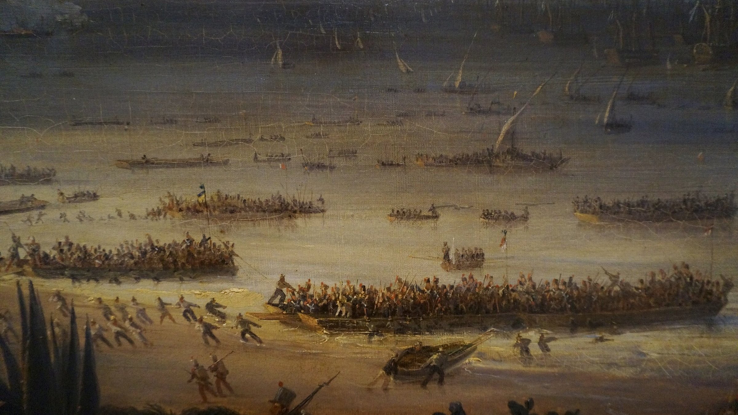 این تصویر یک صحنه دریا را نشان می‌دهد که در آن گروهی از افراد در حال مبارزه یا جابجایی در کنار ساحل هستند. قایق‌های زیادی در آب دیده می‌شوند و آدم‌ها در حال فعالیت‌های مختلفی هستند. فضای کلی پر از حرکت و تنش است.