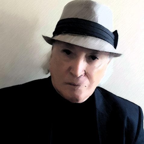 الصورة تظهر شخصًا يرتدي قبعة رمادية مع شريط داكن، وهو يرتدي سترة داكنة أيضًا. لديه ملامح وجه جادة، والخلفية تبدو بسيطة وغير مزدحمة، مما يركز الانتباه على تعبيره وملابسه. توزيع الإضاءة في الصورة يبرز ملامحه بشكل واضح.