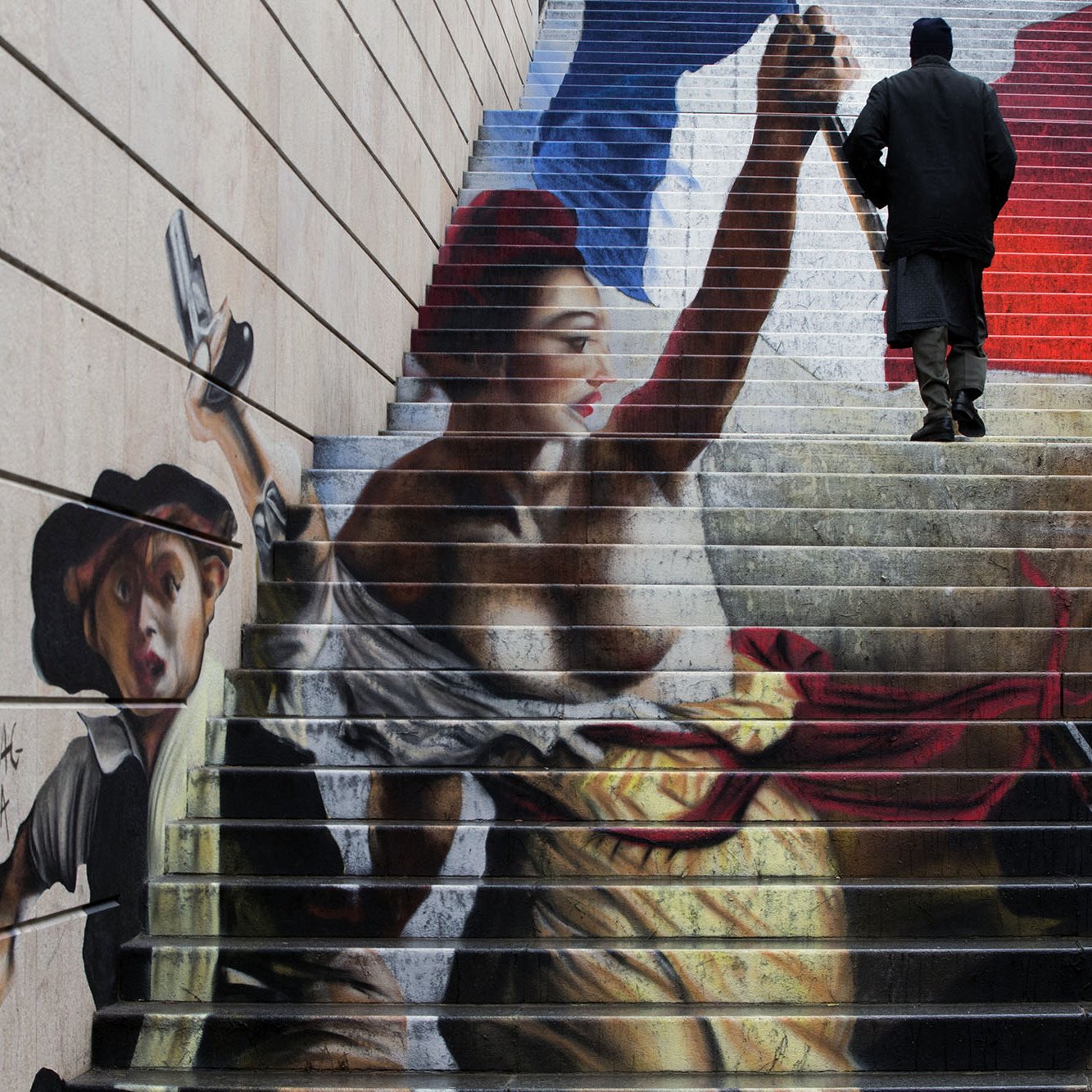الصورة تظهر رسماً جميلاً على درجات سلم، حيث يبرز فيه شخصيتان. إحدى الشخصيات تضم امرأة تحمل سلاحًا وتظهر بشكل قوي ومتعالي، بينما الشخصية الأخرى هي صبي صغير يبدو وكأنه يتحرك بجانبها. الخلفية تحتوي على ألوان وطنية، مثل الأزرق والأبيض والأحمر، مما يشير إلى نوع من الرمزية الوطنية. شخص يرتدي ملابس داكنة يسير فوق الدرجات، مما يعطي إحساسًا بالحركة والديناميكية للصورة.
