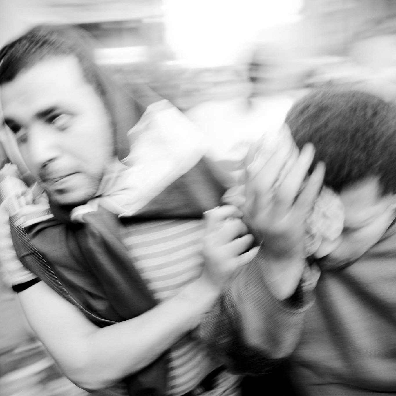 تظهر الصورة رجالاً يتجهون بسرعة في مشهد مزدحم، حيث يبدو أنهم في حالة من الحركة العفوية. الملابس التي يرتدونها متنوعة، ومن الواضح أن هناك نوعاً من التوتر أو الاضطراب في الوضع. الخلفية غير واضحة بسبب الضبابية، مما يعكس شعوراً بالسرعة أو الارتباك. الأربعاء وشعاراتهم تظهر تشويشاً في المشهد، مما يضيف إلى الديناميكية العامة للصورة.